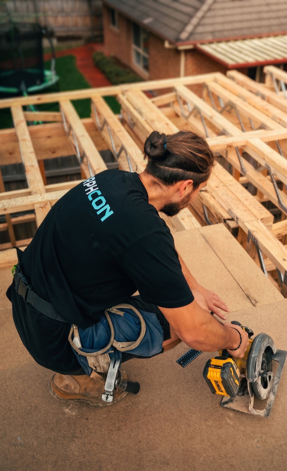 Morphcon director cutting flooring over the floor frame on site